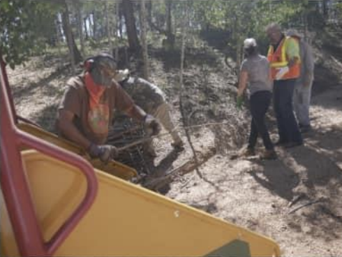 Workers feeding slash into the back of the chipper